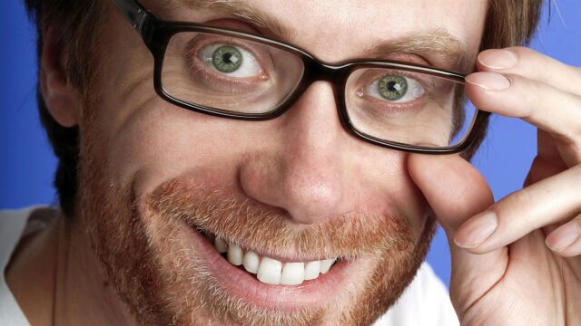 Stephen Merchant Close Up Portrait Smiling with Glasses on Blue Background Wallpapers
