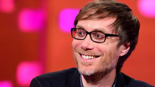Stephen Merchant Close Up Smiling Portrait Wallpaper with Colorful Background
