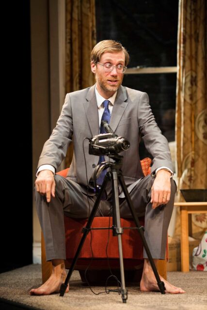 Stephen Merchant Sitting Barefoot in Suit with Camera on Tripod Wallpaper