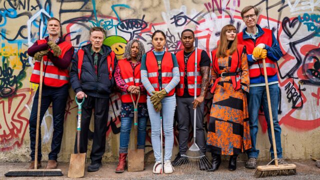 Stephen Merchant Wallpapers Group Wearing Red Safety Vests Standing with Cleaning Tools Against Graffiti Wall
