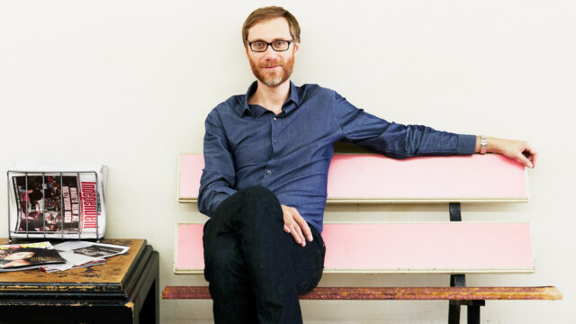 Stephen Merchant casual portrait sitting on pink bench for wallpapers