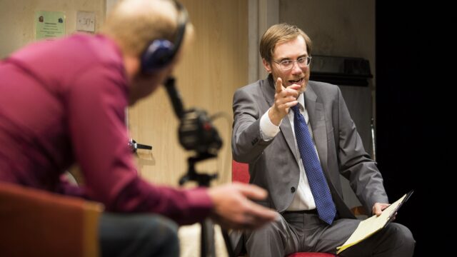 Stephen Merchant in a suit pointing during a recorded interview session wallpaper