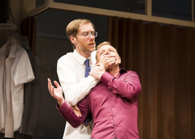 Stephen Merchant intense scene with man in white shirt holding man in purple shirt Wallpapers