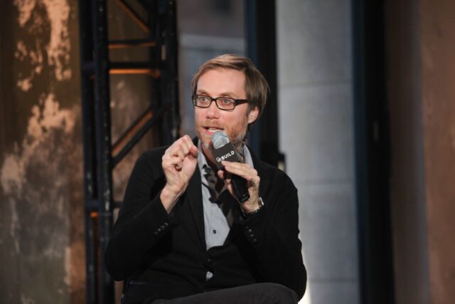 Stephen Merchant speaking at a live event holding microphone in casual black blazer for wallpapers