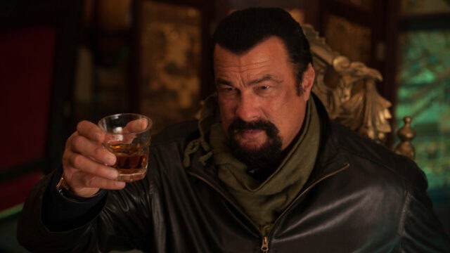 Steven Seagal Holding Glass of Whiskey in Dark Leather Jacket Wallpaper