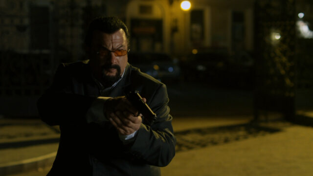 Steven Seagal intense action pose with handgun in dark urban setting for wallpapers