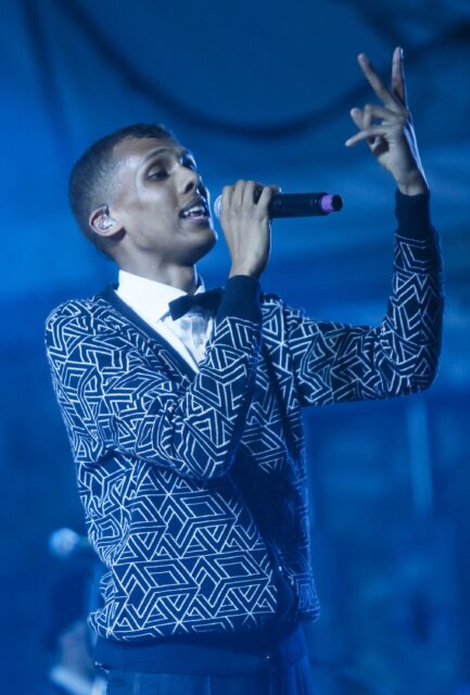 Stromae Performing Live in Geometric Patterned Sweater Wallpaper