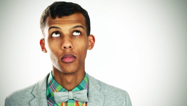 Stromae Stylish Portrait Wallpaper in Colorful Outfit and Bow Tie