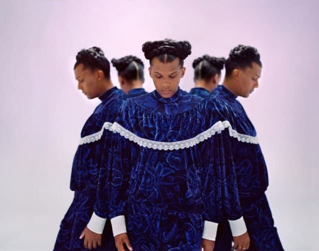 Stromae Wallpapers Artistic Portrait with Elegant Blue Floral Outfit and Braided Hairstyle
