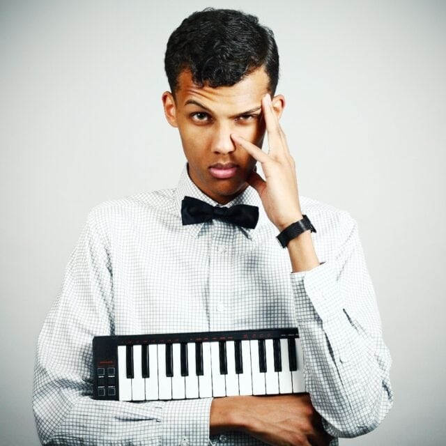 Stromae Wallpapers Featuring Young Musician Holding Mini Keyboard Wearing Bow Tie