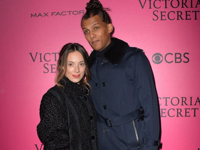 Stromae and partner posing at Victoria Secret event stylish wallpaper background