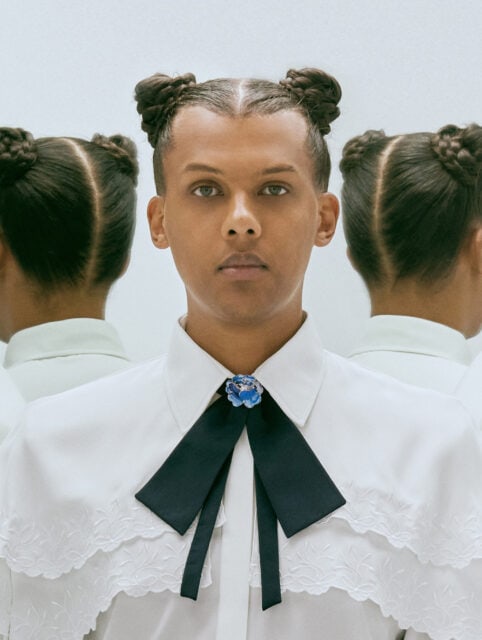 Stromae elegant portrait with braided buns and white shirt perfect for wallpapers