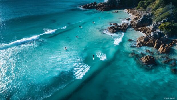 Stunning Surfing Backgrounds Free, a peaceful bay with vibrant turquoise waters and surfers enjoying perfect waves.