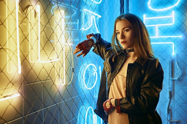 Stylish woman wearing choker and leather jacket in neon light urban setting for choker wallpapers