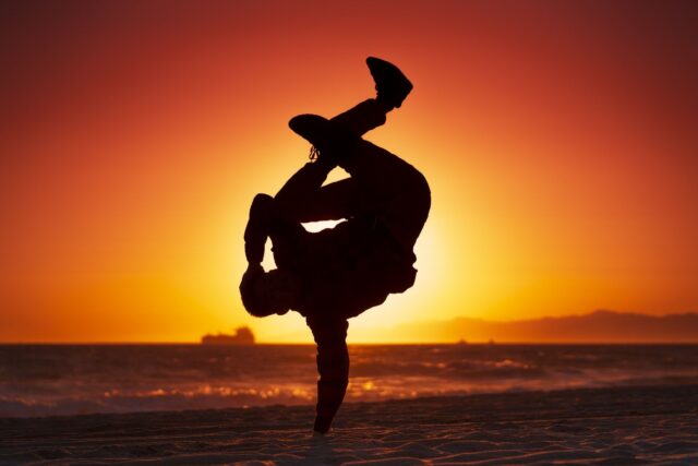 Sunset Breakdancing Silhouette On Beach Wallpaper