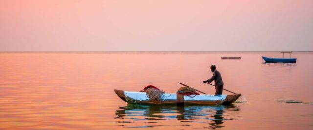 Sunset Serenity On Lake Malawi With Fisherman In Canoe