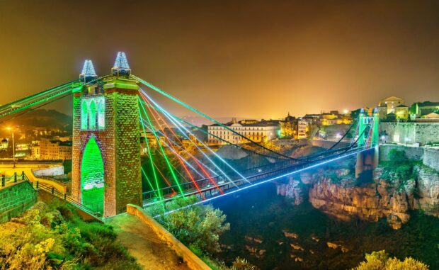 A suspended bridge brightly illuminated at night in Algeria cityscape, HD Desktop Wallpaper