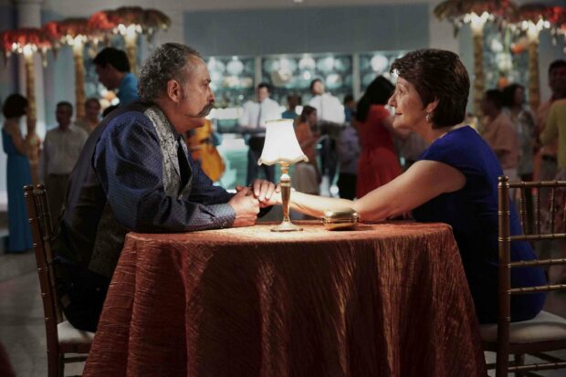 A couple holds hands and shares a tender moment at a warmly lit table during a social event in Jane The Virgin Wallpapers, 2K Desktop Wallpa