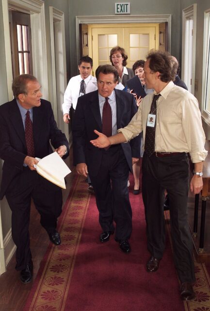 The West Wing TV Series Wallpaper Characters Walking and Discussing in Hallway
