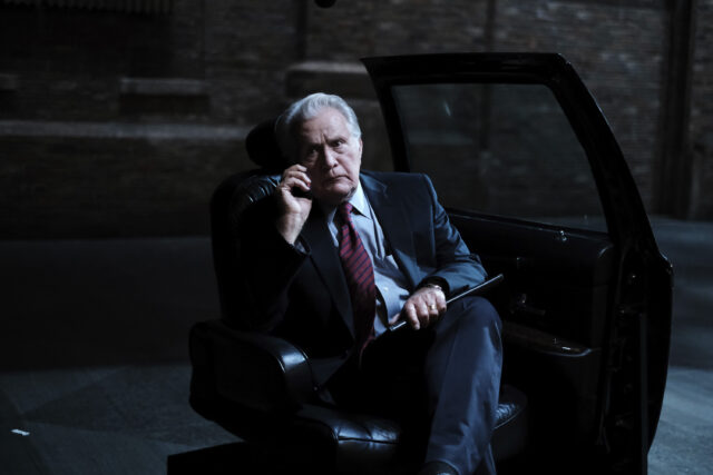The West Wing TV Series Wallpaper Intense Scene with Character on Phone in Dark Setting