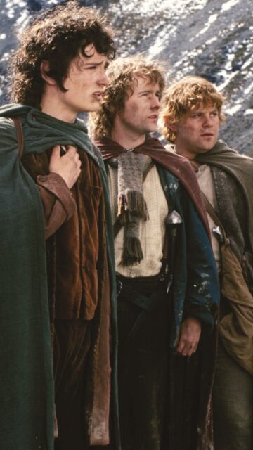 Three Hobbits Standing In The Snowy Mountains Wallpaper
