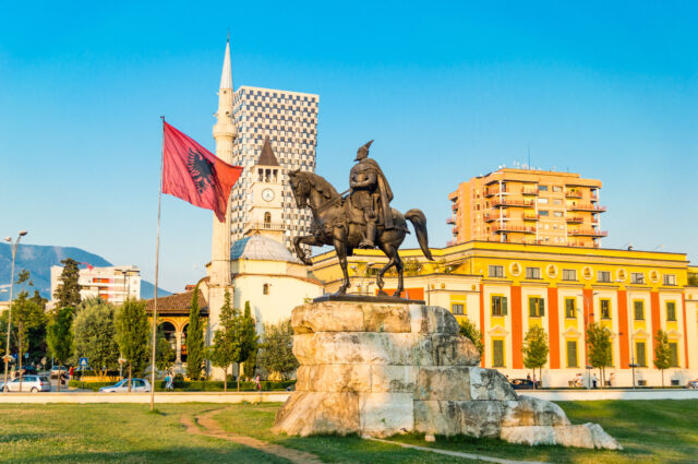 Tirana Albania Scenic Cityscape With Skanderbeg Statue And Flag Wallpaper