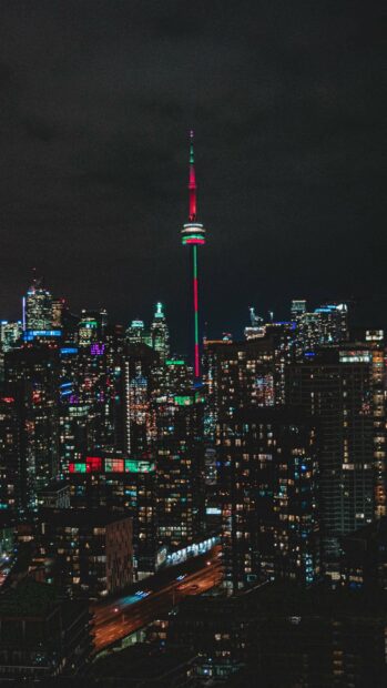 The CN Tower Canada Wallpapers is illuminated against the dark sky and city buildings, 4K Mobile Wallpaper