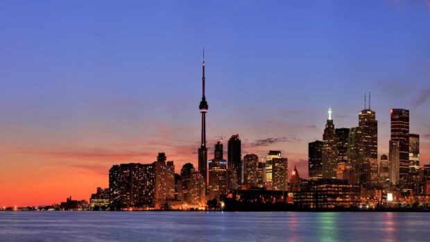 The CN Tower in Canada stands tall among city buildings at dusk, HD Desktop Wallpaper