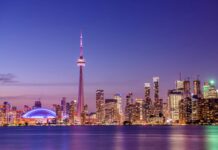 The Toronto skyline features the iconic CN Tower illuminated against a purple sky, HD Desktop Wallpaper