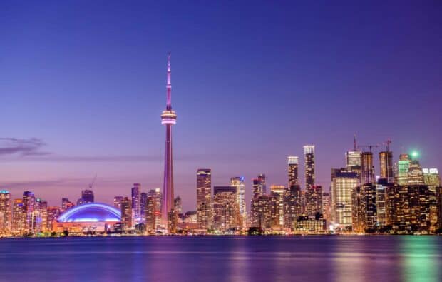 The Toronto skyline features the iconic CN Tower illuminated against a purple sky, HD Desktop Wallpaper