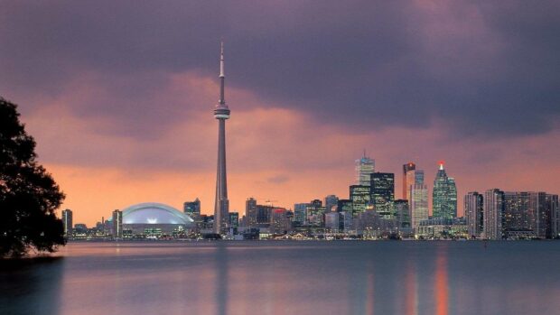 The Toronto skyline features the CN Tower and city buildings against a dramatic sunset sky, HD Desktop Wallpaper
