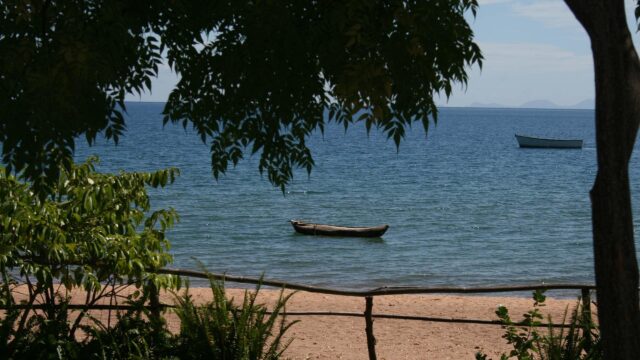 Tranquil Lake Malawi View With Boats And Sandy Beach