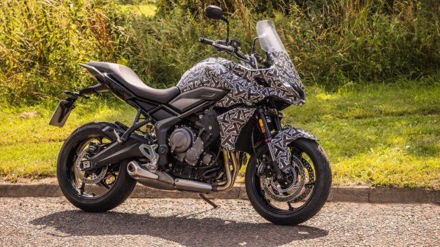 Triumph Tiger Sport 660 Motorcycle Camouflaged Design in Outdoor Setting Wallpaper