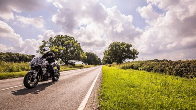 Triumph Tiger Sport 660 Riding on Open Road with Scenic Countryside Background
