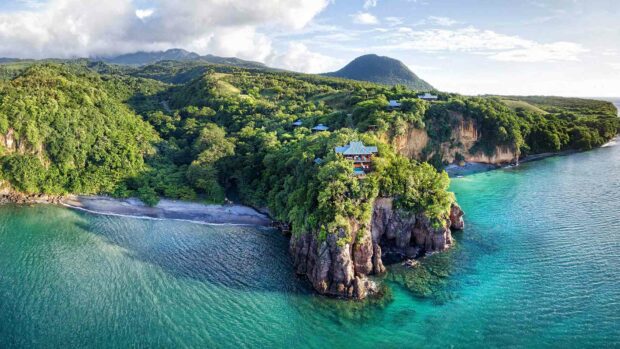 The photo shows a tropical coastline with lush green hills and clear turquoise water typical of Dominica, HD Desktop Wallpaper