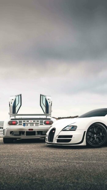 This image shows two white Bugatti Veyron cars, one with doors open and the other facing forward on a cloudy day, 4K Phone Wallpaper