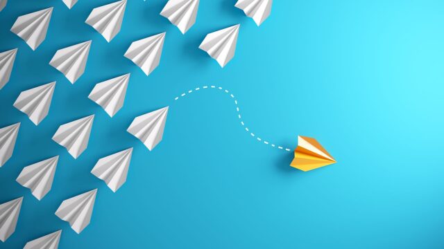 Unique Yellow Paper Plane on Blue Background Flying Away