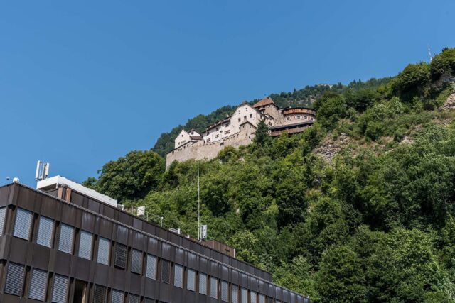 Vaduz Castle On Hill With Modern Building Below Wallpaper