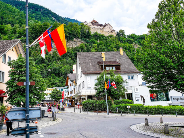 Vaduz Cityscape With Castle And Flags Background
