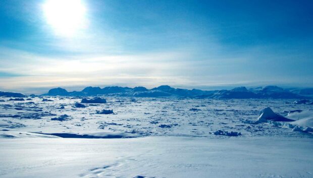 A vast Arctic landscape stretches under a bright blue sky with distant mountains, HD Desktop Wallpaper