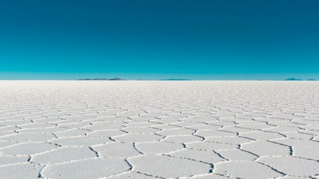 The vast salt flats in Bolivia stretch under a clear blue sky with distant mountains on the horizon, HD Desktop Wallpaper