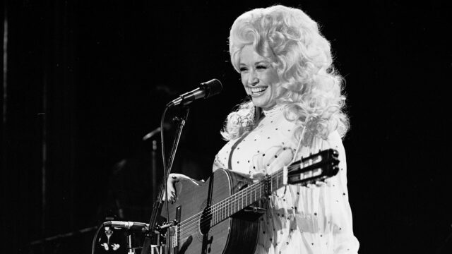 Vintage Dolly Parton Performing With Guitar Black And White Wallpaper