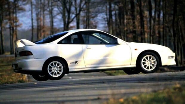 A white Honda Integra Type R is captured driving on an open road with trees in the background, HD Desktop Wallpaper