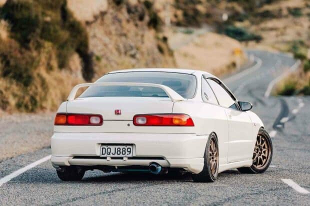 A white Honda Integra is parked on a winding road with dry vegetation in the background, HD Desktop Wallpaper