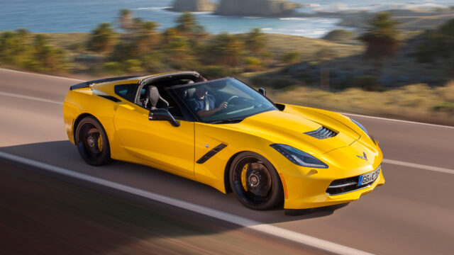 Yellow Chevrolet Corvette Driving On Scenic Coastal Road Wallpaper