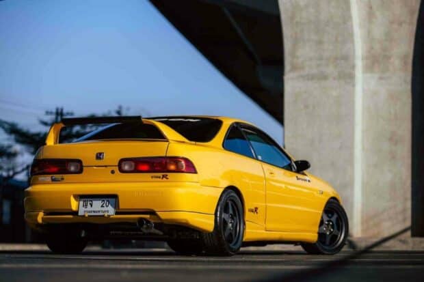 A yellow Honda Integra Type R is parked under a bridge with a clear blue sky in the background, HD Desktop Wallpaper