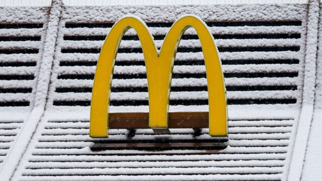 Yellow McDonalds Logo Covered in Snow on Winter Background for Wallpapers