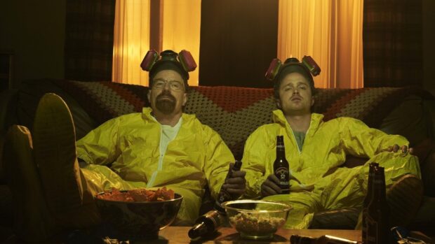 Aaron Paul and Walter White relax in yellow hazmat suits holding beers on a couch, HD Desktop Wallpaper