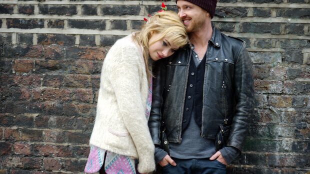 Aaron Paul wearing a leather jacket and smiling beside a woman leaning on his shoulder, 4K Desktop Wallpaper