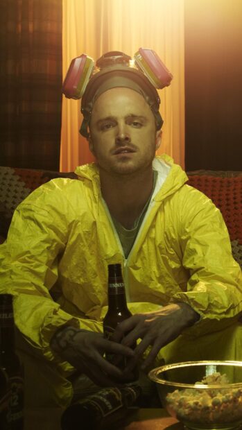 Aaron Paul is sitting with a beer bottle wearing a yellow protective suit and gas mask, HD Phone Wallpaper